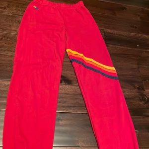 Aviator nation KIDS red sweatpants with 4 stripes across the mid leg.